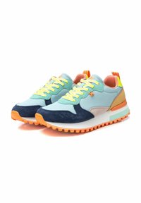 Sneakers sportivi che presentano un mix di materiali: pelle azzurro chiaro, suede navy, dettagli beige e una suola in gomma arancione. Lacci gialli vivaci.