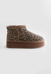 Kotníkové boty s leopardím vzorem vyrobené z měkké tkaniny, s rounded špičkou, elastickým panelem a silnou hnědou platformou. Očko pro snadné obouvání.