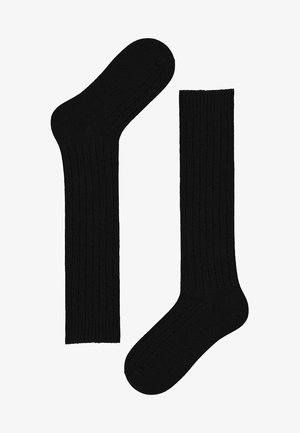 Czarne skarpetki prążkowane, wykonane z miękkiego materiału, o klasycznym wzornictwie, z gładkim wykończeniem i lekko elastyczną teksturą.