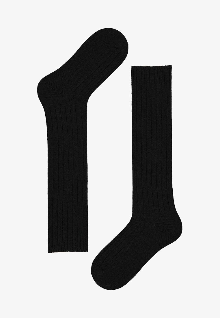 Calze nere a coste, realizzate in tessuto morbido, con un design classico e una finitura liscia, caratterizzate da una texture leggermente elastica.