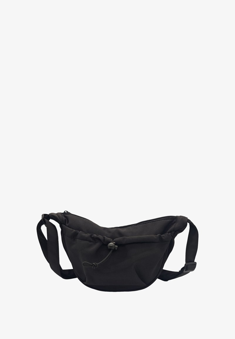 Sac banane en tissu noir de forme arrondie, avec une sangle réglable, un dessus zippé et un bord supérieur froncé. Dispose d'un cordon à bascule pour la fermeture.