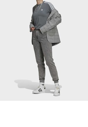 Grå skjorta med tre vita ränder, grå rutig kavaj, grå byxor, svartvita sneakers och vita strumpor med svarta ränder.