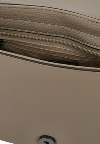 Innenansicht einer beigen Lederbrieftasche mit sichtbarem Reißverschlussfach. Strukturiertes Finish, einfaches Design, silberner Reißverschluss und runde Verschlussdetails.
