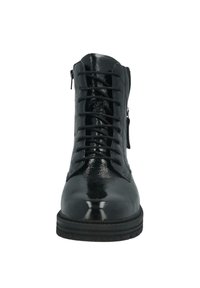 Black shiny leather lace-up ankle boot with side zipper and thick rubber sole, shown from the front.