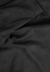 Tessuto in suede nero con una consistenza morbida e liscia, che presenta pieghe e crepe sottili, indicando una caduta flessibile e una qualità leggera.