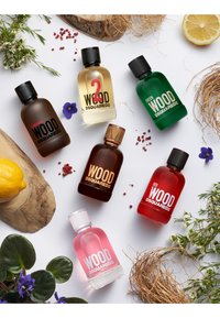 Sept bouteilles de parfums DSQUARED2 disposées avec divers éléments naturels. Comprend des verres marron, vert, rouge, rose et transparent.