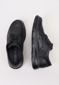 Un par de zapatos de cuero negro con cordones, uno mostrando la vista superior y el otro la vista lateral, con una superficie texturizada y suela robusta.