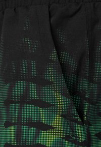 Pantaloni corti neri con un motivo di camuffamento digitale in punti verdi e gialli. Presentano una vita elasticizzata e un tessuto testurizzato.
