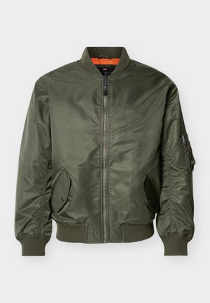 Χακί πράσινο bomber μπουφάν με μπροστινό φερμουάρ, ριμπ μανσέτες και τελείωμα, δύο τσέπες με κουμπιά και τσέπη με φερμουάρ στο αριστερό μανίκι.