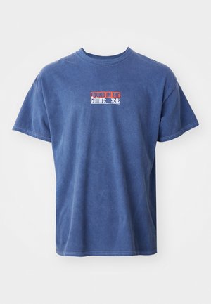 Tricou din bumbac albastru, cu guler rotund și mâneci scurte. Partea din față afișează textul "FOUND IN THE Culture: 文化" în culori contrastante.