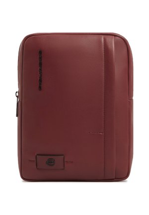 Rechteckige kastanienbraune Leder-Umhängetasche mit vertikaler Steppung, schwarzem Logo auf der Vorderseite und einem Reißverschluss an der linken Seite.