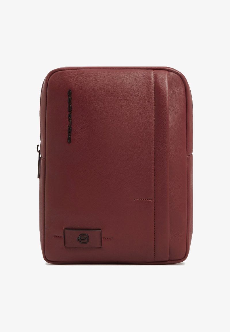 Sac bandoulière rectangulaire en cuir bordeaux avec des coutures verticales, logo noir sur le devant, et une fermeture éclair sur le côté gauche.