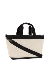 Beige lærredsnettaske med sorte detaljer. Har en rektangulær form, to håndtag øverst og en aftagelig, justerbar skulderrem.