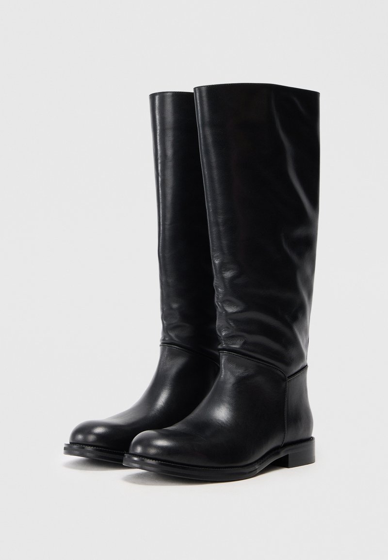 Schwarze Lederstiefel bis zum Knie mit glatter Oberfläche, runder Spitze und flacher Sohle. Einfaches Design ohne sichtbare Beschläge oder Verzierungen.