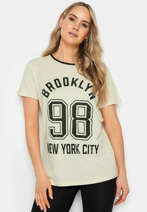 Crème-kleurig katoenen t-shirt met zwarte accenten, voorzien van de opdruk "BROOKLYN 98" en "NEW YORK CITY" in vetgedrukte letters aan de voorkant.