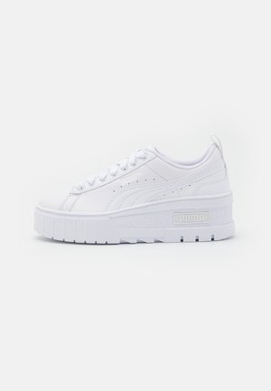 Biały niski sneaker Puma z masywną podeszwą, sznurowaniem z przodu i subtelnymi perforacjami na bocznym panelu.