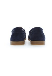Marineblaues Wildleder-Loafer mit braunen Gummisohlen und doppelten Metallverschlüssen. Abgerundete Rückseite mit glatter Textur, minimalistischem Design und ohne sichtbare Muster.