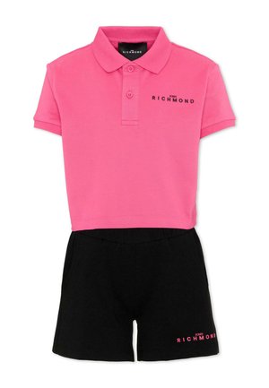 Polo rosa corta con pantaloncini neri, entrambi con il logo "John Richmond" in colori contrastanti.