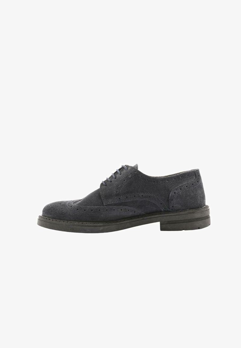 Scarpa oxford in suede grigio scuro con dettagli brogue, punta rotonda, suola nera piatta e chiusura con lacci a sei fori. Finitura texture.