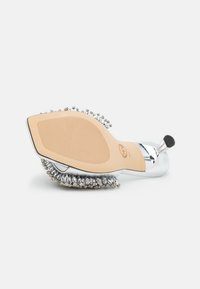 Chaussure à talon argentée avec une semelle beige texturée, accents en strass scintillants autour du talon, et une finition lisse et brillante.