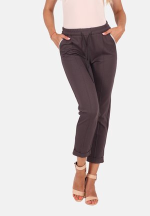 Dark gray elastic waist pants with cuffed hems, side pockets, and drawstring details. Worn with beige ankle-strap heels.