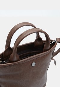 Borsa a tracolla in pelle marrone con texture, dotata di due manici e chiusura a scatto magnetico, parzialmente aperta che mostra la tasca con zip interna e l'attacco della tracolla.