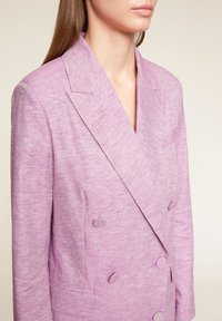 Dvoubreasted levandulový blejzr s texturovanou látkou, klopami s výřezem, dvěma předními kapsami a kulatými knoflíky jako zdobením.