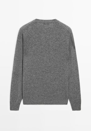 Maglione grigio a maglia, con maniche lunghe, colletto rotondo e una consistenza morbida. Design semplice senza motivi o accenti visibili.