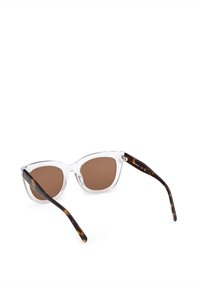 Ruskeat aurinkolasit, joissa on kirkkaat kehykset ja tummat kilpikonnakuosiset varret, kissansilmämuoto ja sileä pinta.