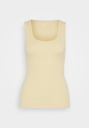 Top giallo a coste con scollatura quadrata. Design aderente, tessuto morbido e bordi senza cuciture. L'etichetta del marchio è visibile al centro in alto.
