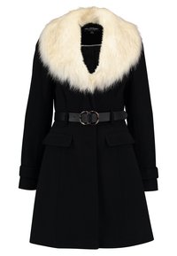 Manteau en laine noire avec large col en fausse fourrure blanche, ceinture noire avec boucle double anneau, poches à rabat et manches retroussées.