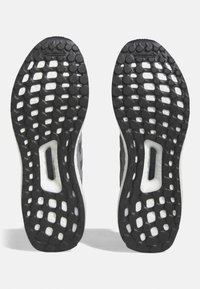 Svarta gummisulor med varierande cirkulära mönster och framträdande spår för grepp, med en vit mellansula och Continental-logotyp.