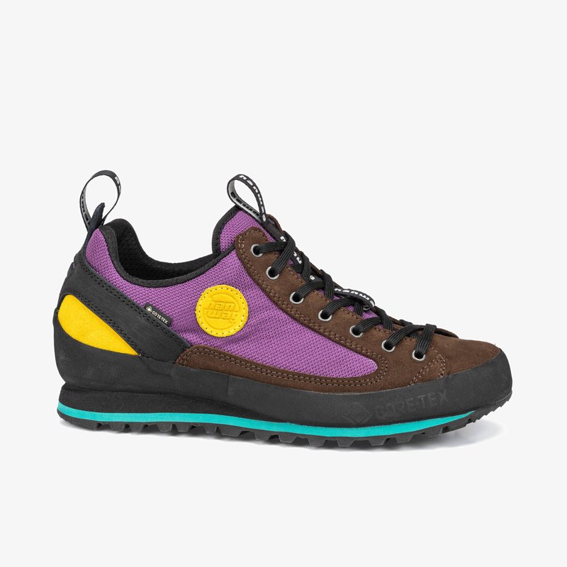 Chaussure d'escalade à décolleté bas en tissu violet avec des accents en suède marron. Caractérisée par une patch logo jaune, des lacets noirs et une semelle en caoutchouc noir texturé.