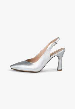 Zapato de tacón alto plateado con punta puntiaguda, tira trasera y hebilla dorada, con tacón ancho curvado sobre fondo blanco.