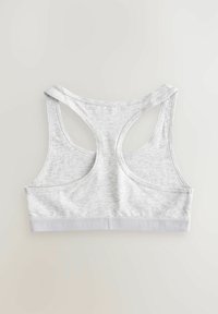 Grå bomulds sport-BH med racerback-design. Har en blød tekstur og et bredt, elastisk bånd med mærkenavnet trykt langs det.