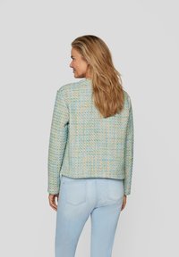 Texturierte Jacke in pastelblauen, gelben und grünen Farbtönen; hat ein kurzes Design mit langen Ärmeln und einem runden Halsausschnitt.