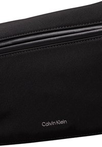 Sacchetto in tessuto nero con dettagli in pelle liscia, dotato di chiusura con zip e del logo "Calvin Klein" in un carattere discreto.