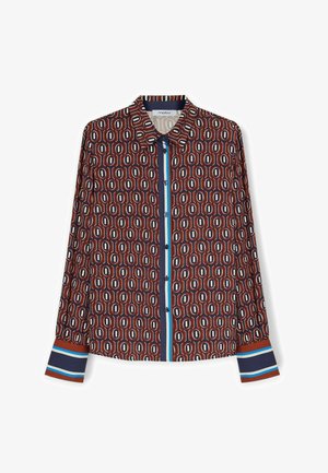 Chemise à manches longues en rouge, bleu marine et beige avec un motif géométrique. Présente un devant à boutons et des poignets contrastés avec des rayures bleu et blanc.