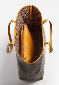 Torba na ramię o szarym kolorze z brązowym wzorem logo, wyłożona wzorem lamparta. Posiada żółte akcenty i wewnętrzną kieszeń zapinaną na zamek.