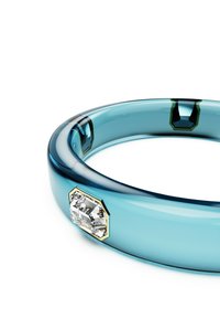 A translucent blue ring with a smooth finish, featuring a clear diamond accent set in an octagonal gold bezel.