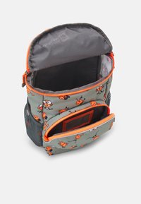 Sac à dos avec une base grise, des accents orange et des motifs de dessins animés. Comprend une poche latérale en filet et des compartiments à double zip. Tissu texturé.