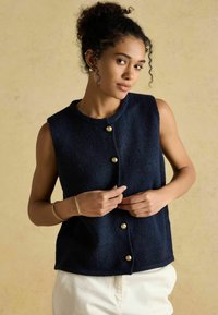 Jūras spēku vilnas bez piedurknēm veste ar apaļo dekoltē, priekšējo pogu aizdari ar zelta toņa pogām un brīvu piegriezumu. Teksturēts audums.