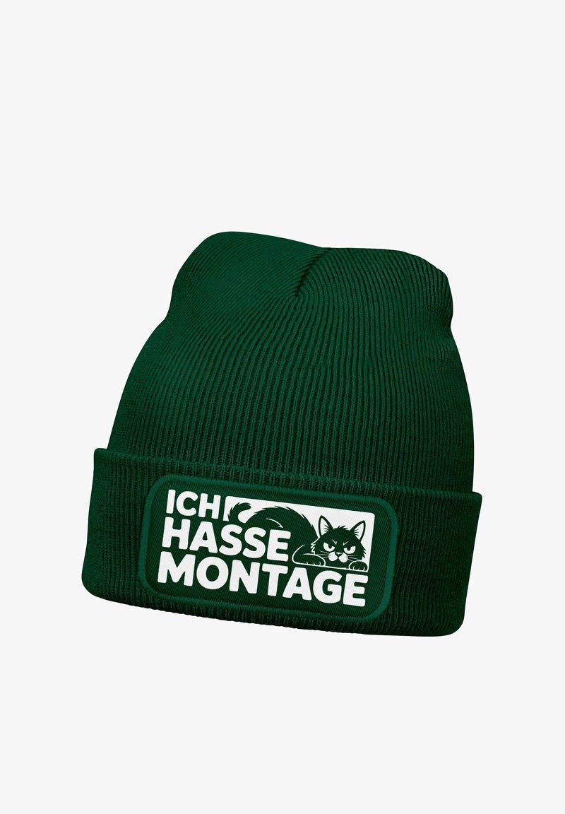 Green knit beanie with a ribbed texture, featuring a rectangular patch displaying the text "ICH HASSE MONTAGE" and a cat graphic.
