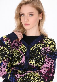 Cardigan lavorato a maglia con un audace motivo multicolore in nero, rosa, giallo e blu, con scollatura a V e chiusura a bottoni.