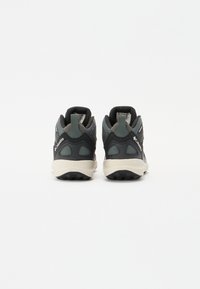 Scarpe da uomo sportive nere e grigie con tomaia in rete testurizzata, linguette per il supporto al tallone e suola in gomma bianca. Presentano dettagli riflettenti e un motivo di battistrada robusto.