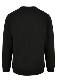 Sweat-shirt noir à manches longues avec col rond montré de dos avec poignets et ourlet côtelés, design simple sans logos ni motifs visibles.