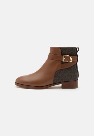Bottine en cuir marron avec dos en tissu foncé à motifs, bride avec boucle dorée et petit talon empilé sur fond blanc.