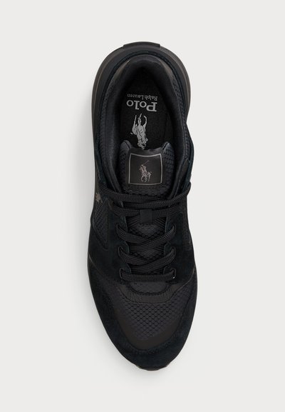 Crne tenisice s kombinacijom antilopa i mrežastih materijala, okrugli vezice, podstavljena ojačanja oko zapešća i oznaka branda na jezičku. Tekstuirana potplata.