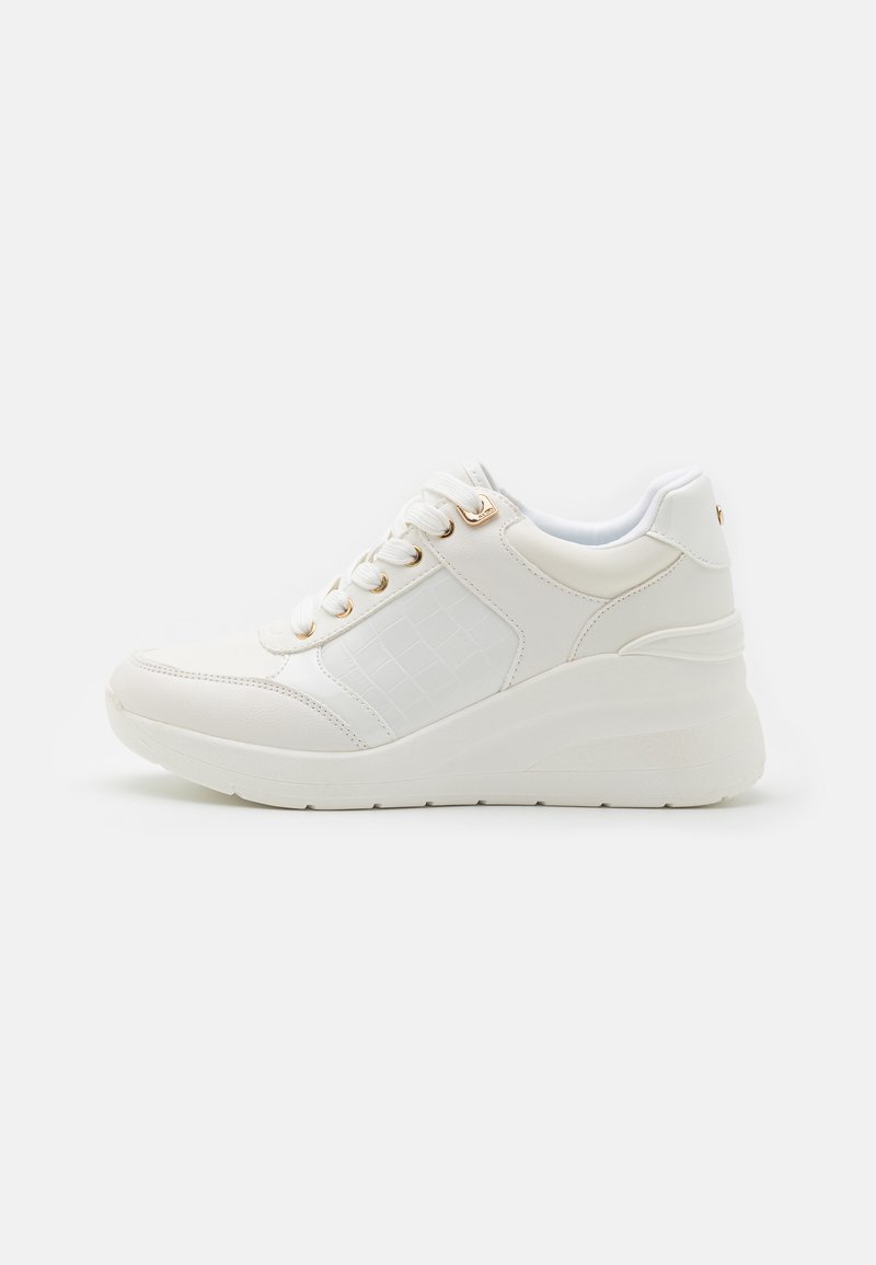Weiße Sneakers mit einem strukturierten, kunstledernen Seitenpanel, auffälligen Schnürsenkeln und einer dicken Wedge-Sohle mit einem subtilen Muster. Goldakzente vorhanden.