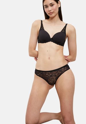 Schwarzer Spitzen-BH mit vorgeformten Cups und verstellbaren Trägern, kombiniert mit passendem schwarzen Spitzen-String mit Blumenmustern und glatten Kanten.